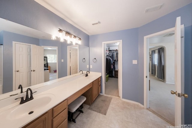 full bath with tile patterned floors, a sink, double vanity, visible vents, and a spacious closet