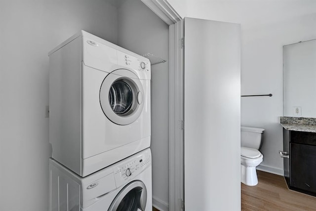 1900 Barton Springs Rd Unit 4023, Austin, TX 78704 - laundry room with stacked washing machine and dryer and wood finished floors