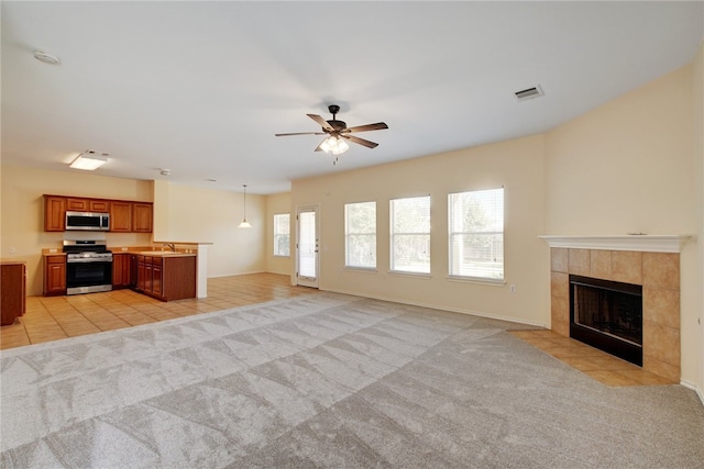 10916 Furrow Hill Dr, Austin, TX 78754 - unfurnished living room featuring a tiled fireplace, ceiling fan, light colored carpet, and light tile patterned flooring