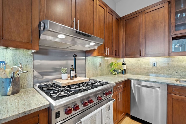 555 E 5th St Unit 2729, Austin, TX 78701 - kitchen with appliances with stainless steel finishes, backsplash, under cabinet range hood, and brown cabinets