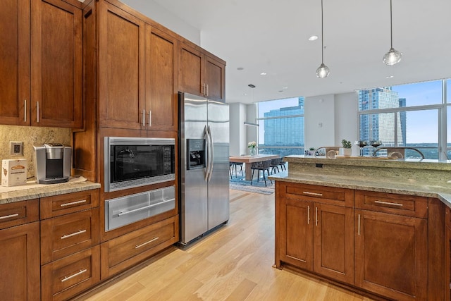 555 E 5th St Unit 2729, Austin, TX 78701 - kitchen with stainless steel fridge with ice dispenser, black microwave, a warming drawer, light wood-style floors, and brown cabinets