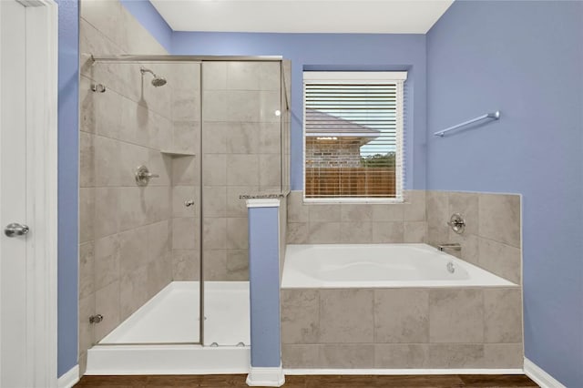 bathroom featuring a shower stall and a garden tub
