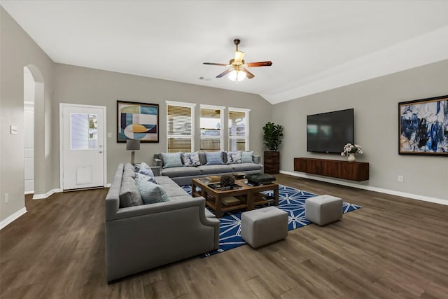 living area with a ceiling fan, baseboards, dark wood-style floors, arched walkways, and lofted ceiling