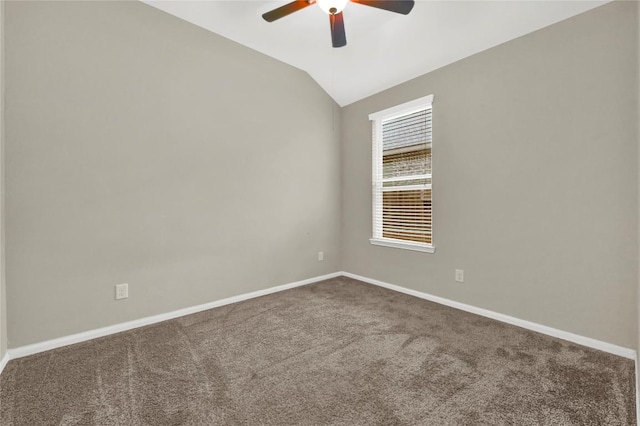 empty room featuring ceiling fan, carpet floors, baseboards, and vaulted ceiling