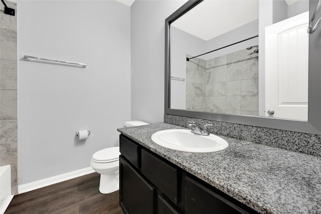 full bathroom with toilet, wood finished floors, vanity, a shower, and baseboards