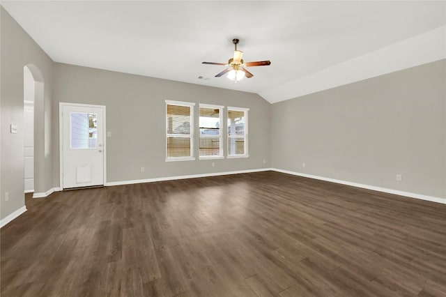 unfurnished living room featuring a ceiling fan, arched walkways, plenty of natural light, baseboards, and vaulted ceiling