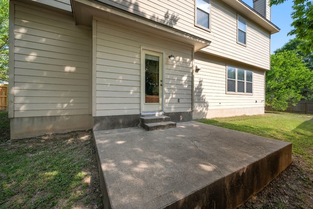 rear view of house featuring a chimney, fence, a yard, a patio, and entry steps