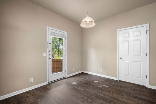 unfurnished room featuring baseboards and dark wood-style floors