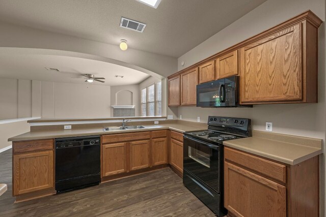 kitchen featuring a peninsula, a sink, visible vents, a ceiling fan, and black appliances