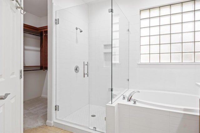 full bath featuring a shower stall, a bath, and tile patterned flooring