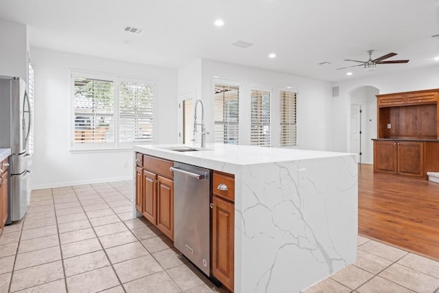 kitchen featuring stainless steel appliances, visible vents, recessed lighting, brown cabinets, and light tile patterned floors