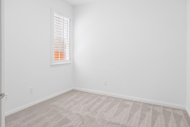 empty room with baseboards and light carpet