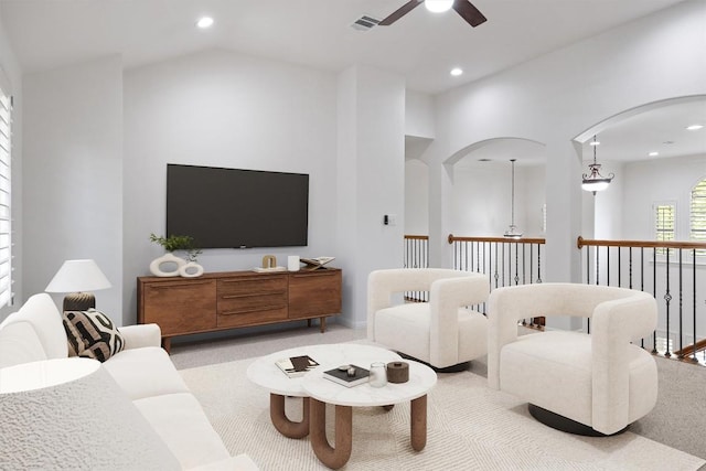 living area featuring recessed lighting, visible vents, light carpet, arched walkways, and ceiling fan