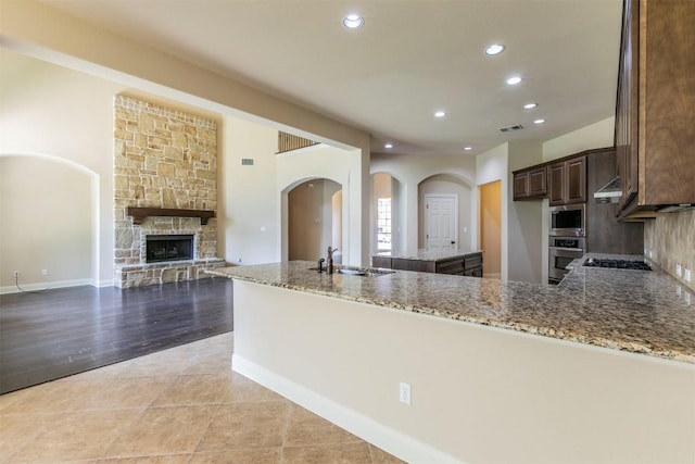 308 Angus Dr, Cedar Park, TX 78613 - kitchen featuring a sink, arched walkways, light stone countertops, recessed lighting, and appliances with stainless steel finishes