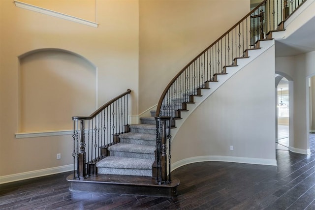 308 Angus Dr, Cedar Park, TX 78613 - staircase featuring arched walkways, a high ceiling, hardwood / wood-style flooring, and baseboards