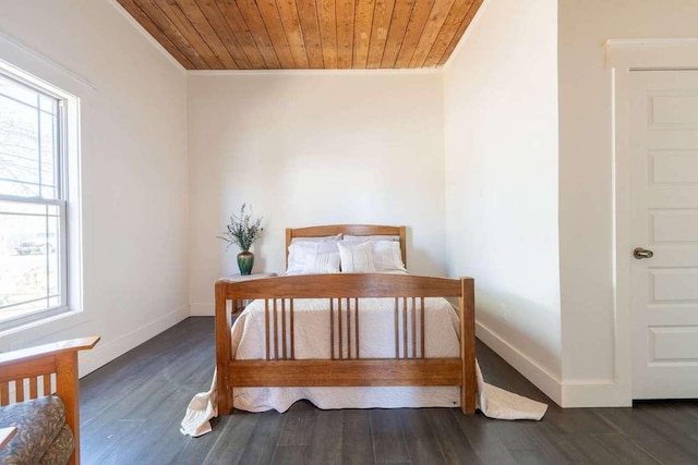 bedroom with crown molding, wood finished floors, baseboards, and multiple windows