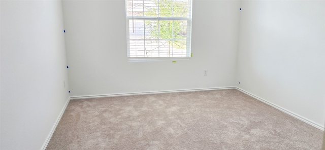 carpeted empty room featuring baseboards