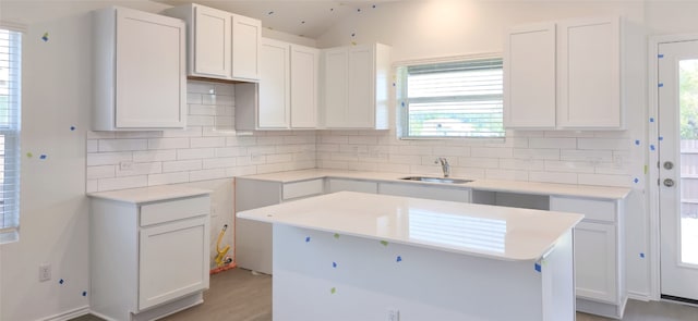 kitchen featuring backsplash, a sink, and plenty of natural light