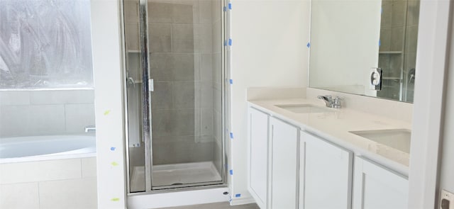 full bath with a garden tub, a sink, double vanity, and a stall shower