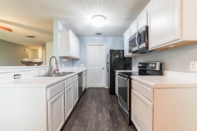 3005 Tyler Ln, Taylor, TX 76574 - kitchen featuring appliances with stainless steel finishes, a sink, a peninsula, dark wood finished floors, and light countertops