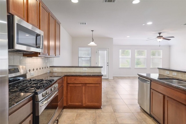 1317 Rimstone Dr, Cedar Park, TX 78613 - kitchen featuring appliances with stainless steel finishes, decorative backsplash, brown cabinetry, and recessed lighting