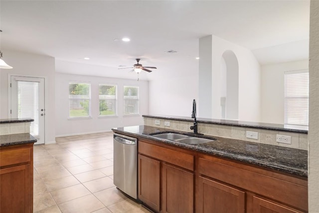 1317 Rimstone Dr, Cedar Park, TX 78613 - kitchen with dishwasher, dark stone countertops, a ceiling fan, light tile patterned flooring, and brown cabinets