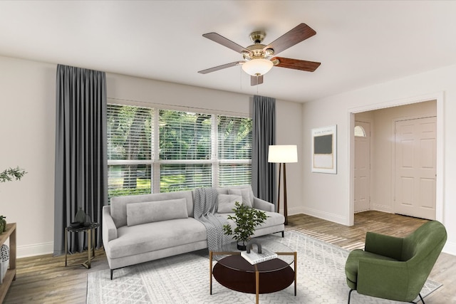 living room with baseboards, a ceiling fan, and wood finished floors