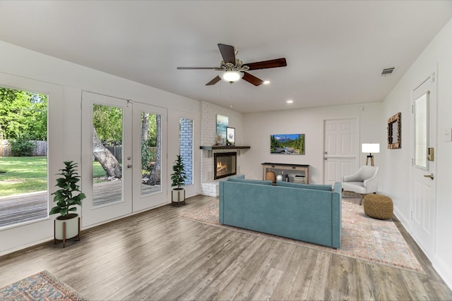 living room with recessed lighting, wood finished floors, visible vents, a brick fireplace, and ceiling fan