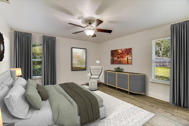 bedroom featuring baseboards, wood finished floors, and multiple windows