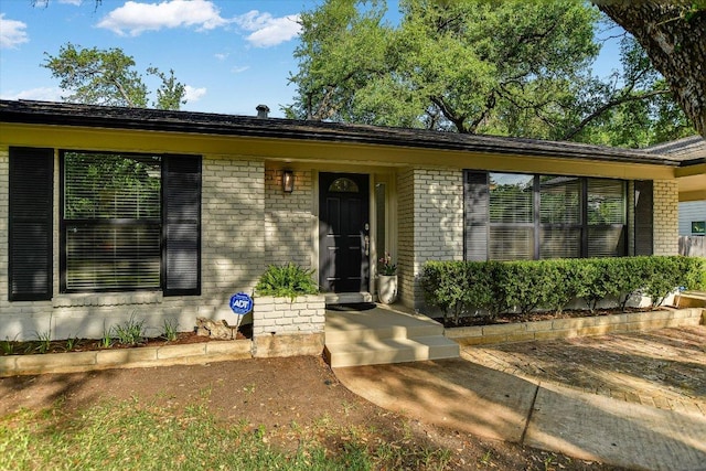 property entrance featuring brick siding