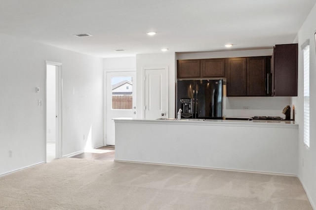 2305 Tornado Aly, Lockhart, TX 78644 - kitchen featuring dark brown cabinets, black refrigerator with ice dispenser, recessed lighting, light carpet, and a peninsula