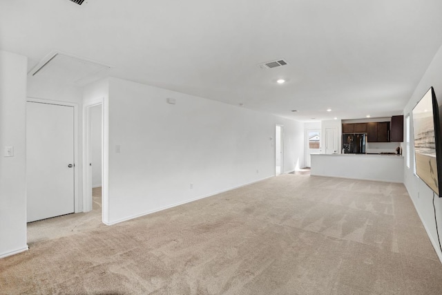 2305 Tornado Aly, Lockhart, TX 78644 - unfurnished living room featuring visible vents, attic access, light carpet, and recessed lighting