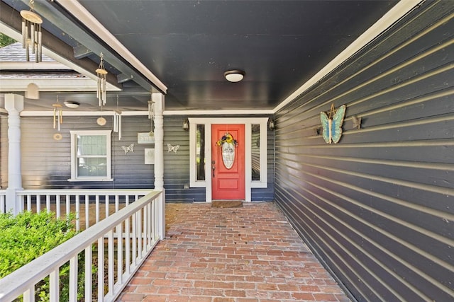 view of exterior entry featuring covered porch