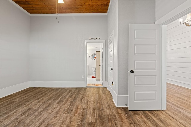 unfurnished room featuring wood ceiling, baseboards, wood finished floors, and an inviting chandelier