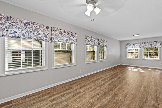 interior space featuring wood finished floors, a ceiling fan, and baseboards