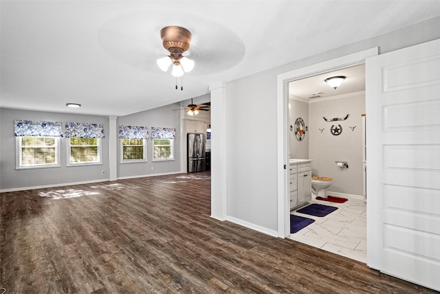 interior space featuring wood finished floors, baseboards, a wealth of natural light, and ornamental molding