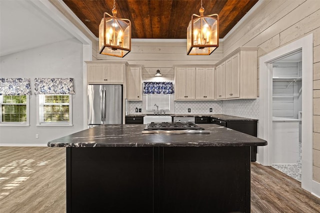 kitchen with tasteful backsplash, wood finished floors, stainless steel appliances, wooden ceiling, and a kitchen island