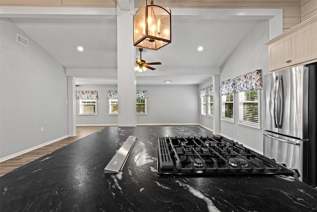interior space featuring visible vents, freestanding refrigerator, stovetop, lofted ceiling with beams, and open floor plan