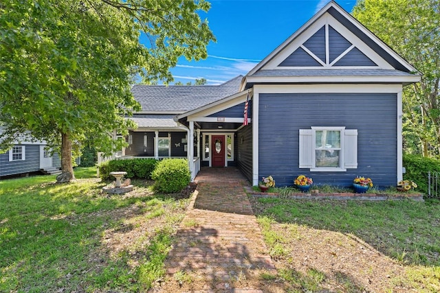 view of front of home featuring a front lawn and roof with shingles
