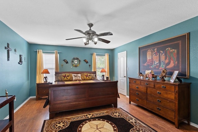 2205 Milan Dr, Cedar Park, TX 78613 - bedroom featuring wood finished floors, a ceiling fan, and baseboards