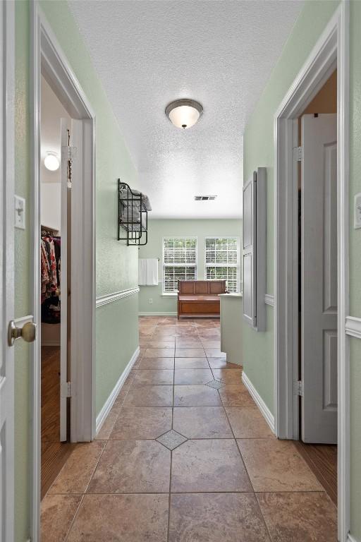 2205 Milan Dr, Cedar Park, TX 78613 - hallway with a textured ceiling, baseboards, and tile patterned floors