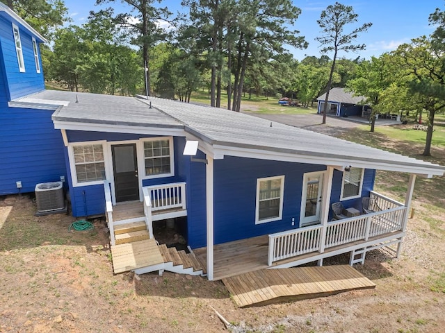 129 Valley Spur, Smithville, TX 78957 - view of front facade featuring central air condition unit, roof with shingles, and covered porch