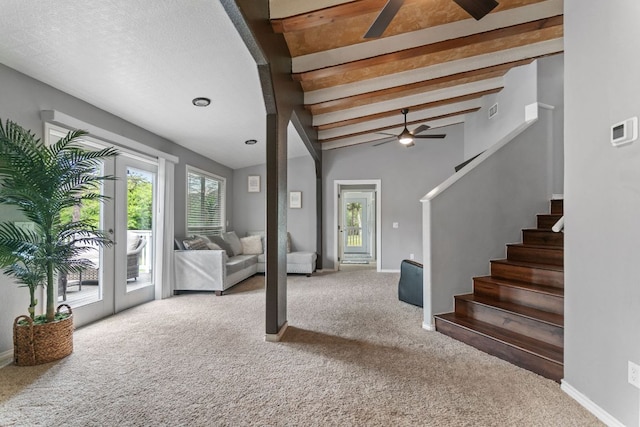 129 Valley Spur, Smithville, TX 78957 - unfurnished living room featuring stairway, a ceiling fan, and carpet
