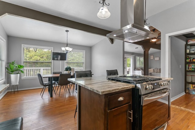 129 Valley Spur, Smithville, TX 78957 - kitchen with stainless steel gas stove, island range hood, light wood-style flooring, and healthy amount of natural light