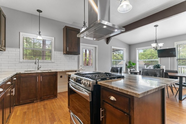 129 Valley Spur, Smithville, TX 78957 - kitchen with light stone counters, island range hood, a sink, gas stove, and decorative backsplash
