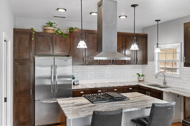 129 Valley Spur, Smithville, TX 78957 - kitchen with stainless steel fridge, island range hood, gas stovetop, backsplash, and light stone counters
