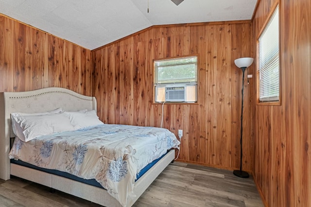 129 Valley Spur, Smithville, TX 78957 - bedroom with vaulted ceiling, wood walls, wood finished floors, and cooling unit