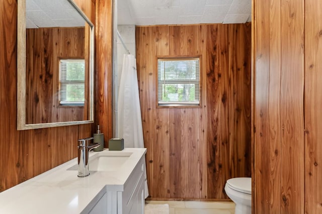 129 Valley Spur, Smithville, TX 78957 - full bath featuring a shower with curtain, wood walls, vanity, and toilet
