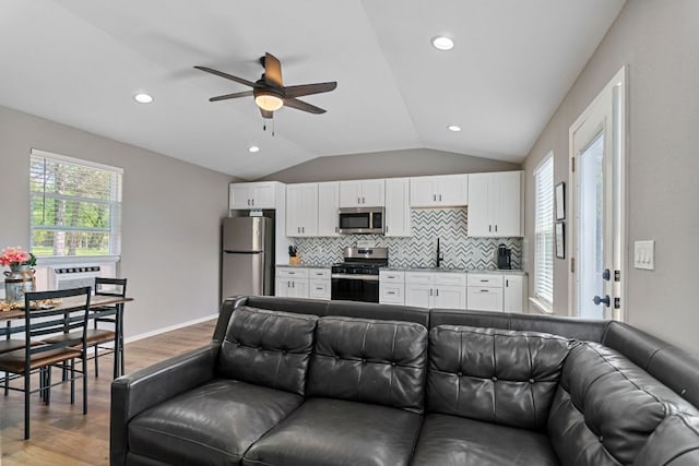 129 Valley Spur, Smithville, TX 78957 - living area with lofted ceiling, a ceiling fan, wood finished floors, and recessed lighting