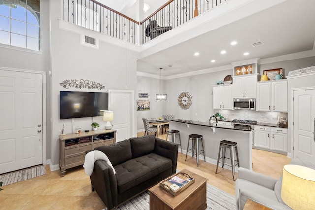 218 Sunrise Ridge Loop, Lakeway, TX 78738 - living area with a high ceiling, light tile patterned floors, crown molding, and recessed lighting